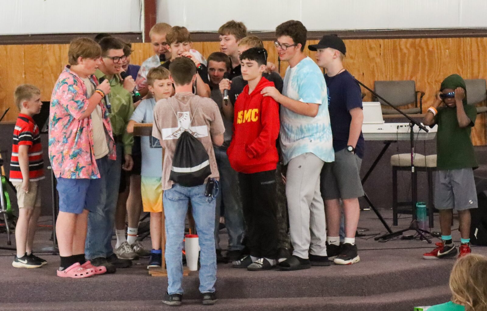 Campers singing together on stage during a service