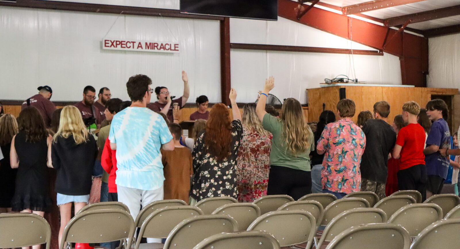 Campers worshipping with hands raised during a service