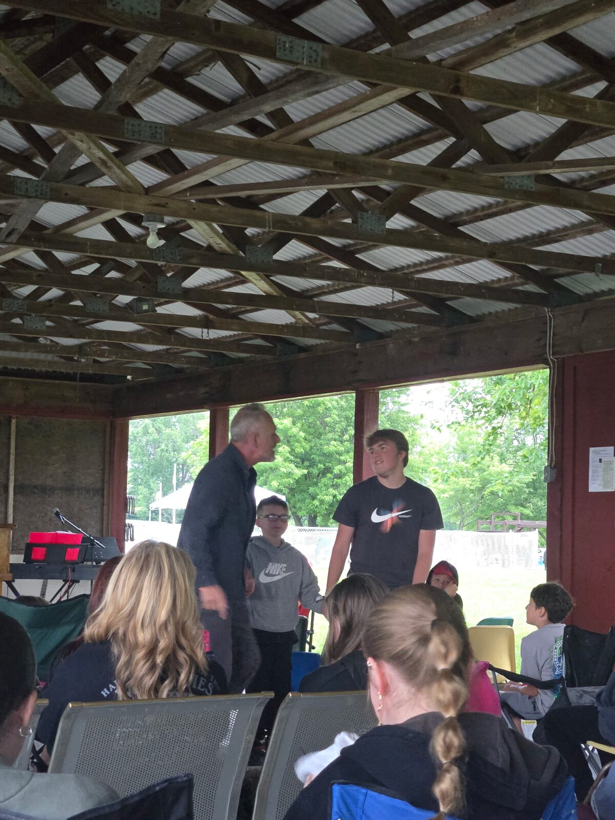 A speaker talking with campers on stage during a service